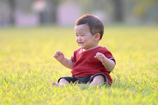 芝生で笑う赤ちゃん