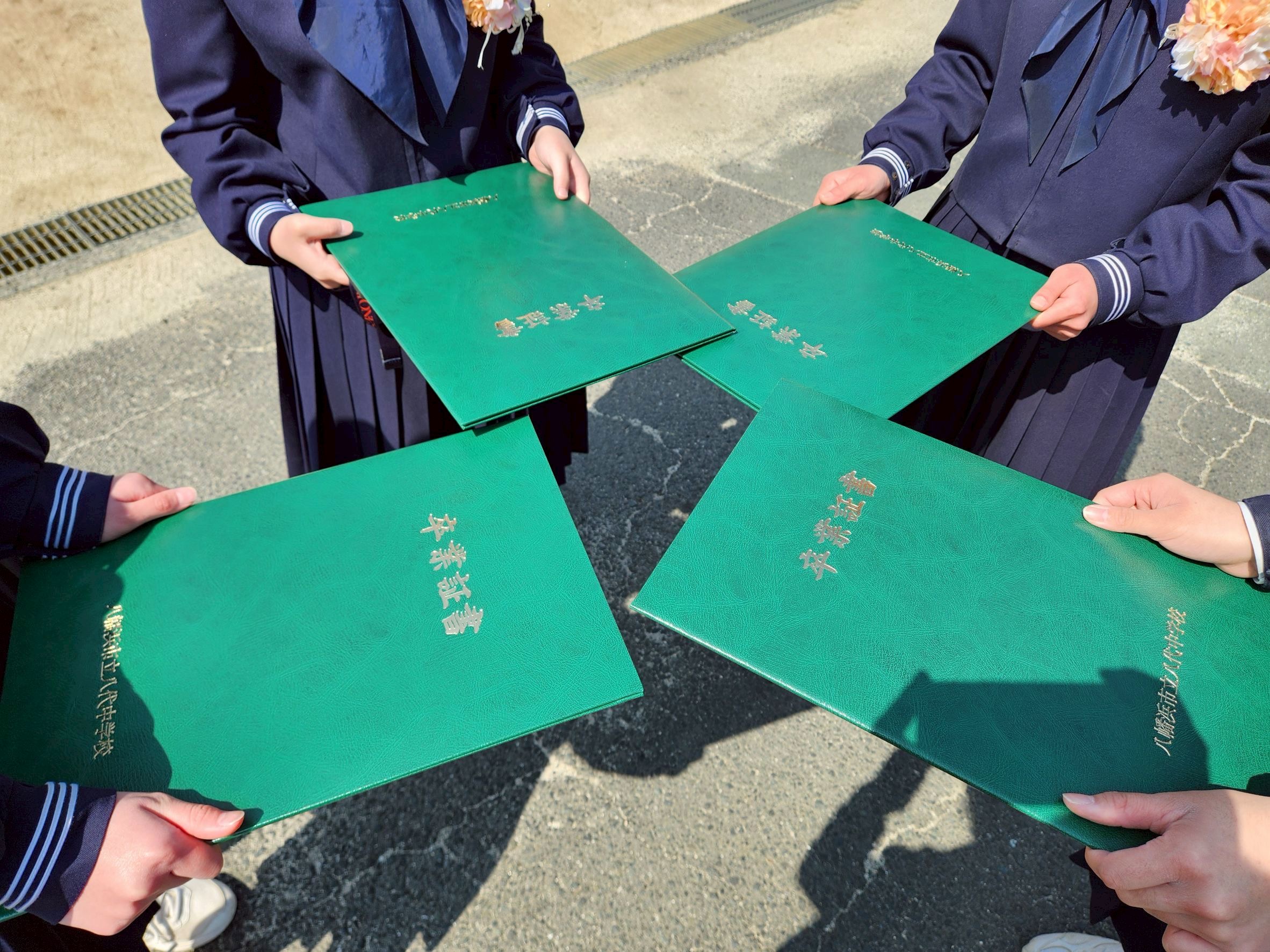 卒業証書を手にする中学生たち